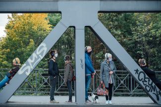 © Lukas Probst Personen mit Kopfhörern stehen auf einer Brücke.